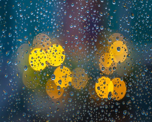 A glass of water next to an open window in the morning light